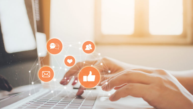 Hand of businessman using laptop with icon social media and social network. Online marketing concept