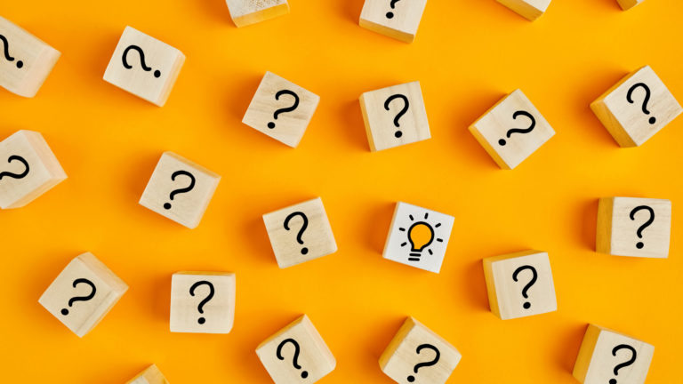 Concept of to find a creative idea or problem solving. Question mark and light bulb icons on wooden cubes